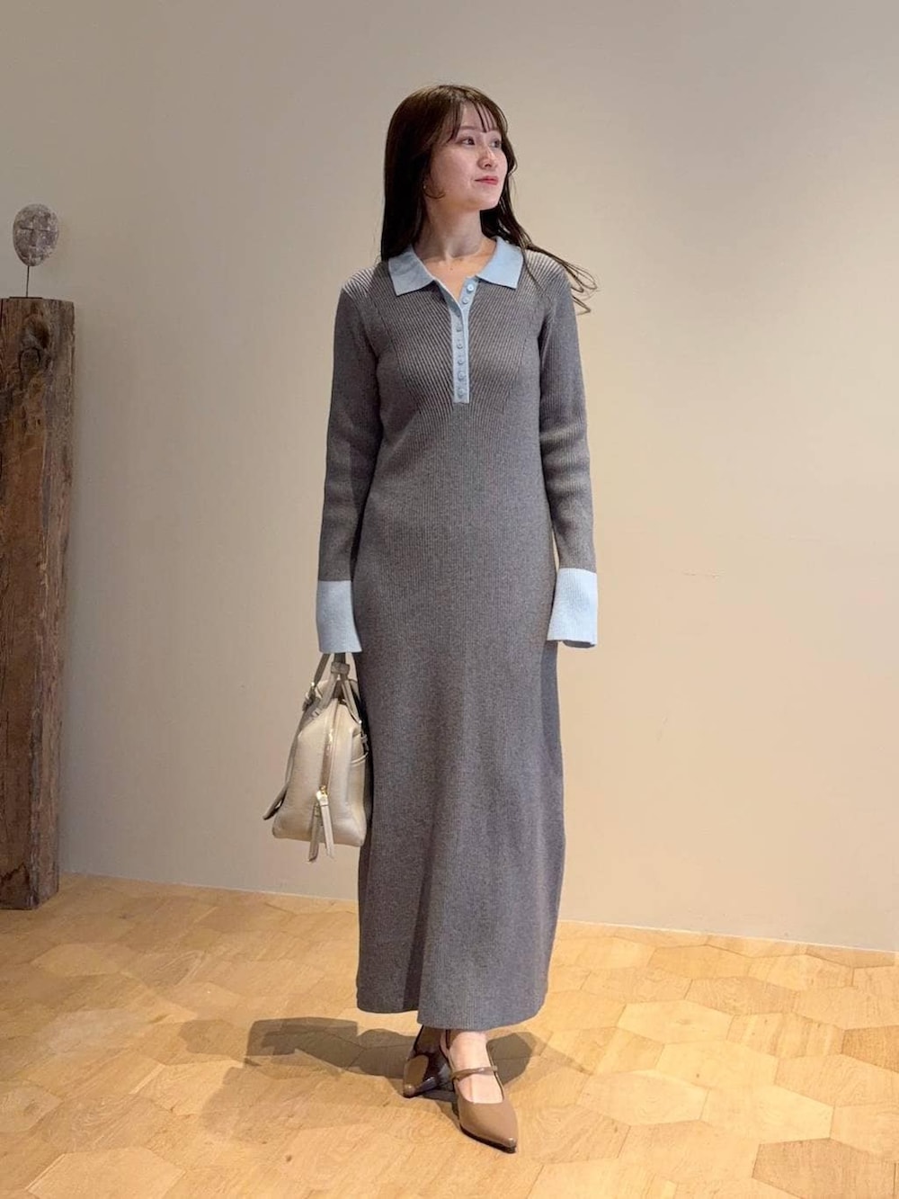 ベージュ系のハンドバッグ、グレー系のワンピース、ブルー系のデニムジャケットを着用したレディースの春コーディネートの3枚目の写真