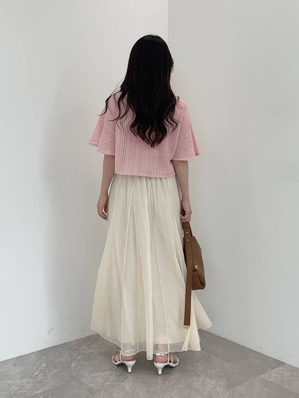 ブラウン系のショルダーバッグ、ホワイト系のサンダル、ホワイト系のスカートを着用したレディースの夏コーディネートの2枚目の写真