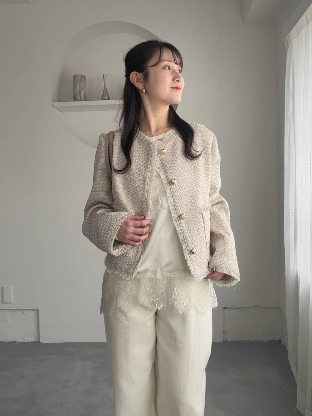 ブラウン系のサンダル、ホワイト系のキャミソール、ホワイト系のノーカラージャケットを着用したレディースの春コーディネートの3枚目の写真