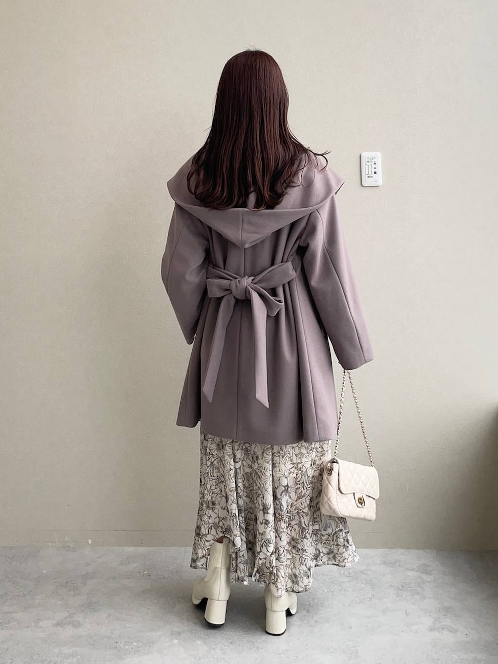 ブラウン系のノーカラーコート、ホワイト系のスカート、ホワイト系のショルダーバッグを着用したレディースの秋コーディネートの2枚目の写真