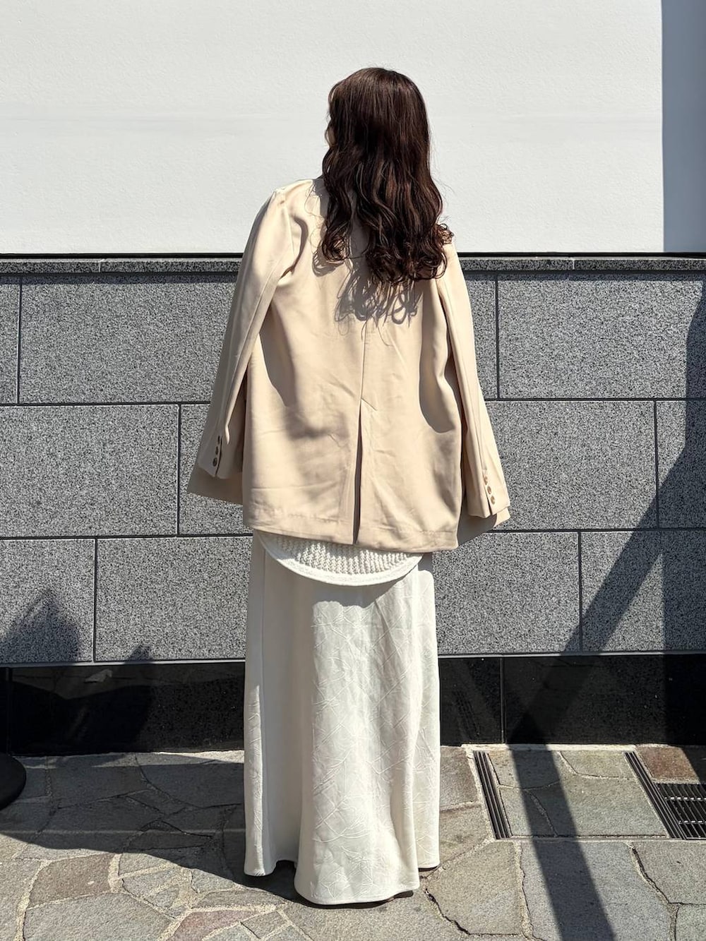 ホワイト系のスカート、ピンク系のTシャツ/カットソー、ブラウン系のボストンバッグを着用したレディースの春コーディネートの2枚目の写真