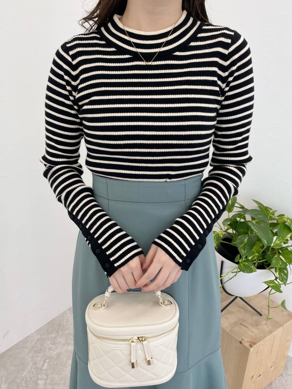 グレー系のブーツ、ブルー系のスカート、ブラック系のニット/セーターを着用したレディースの冬コーディネートの3枚目の写真