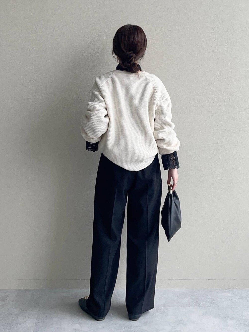 ホワイト系のニット/セーター、ブラック系のハンドバッグ、ブラック系のシャツ/ブラウスを着用したレディースの秋コーディネートの2枚目の写真