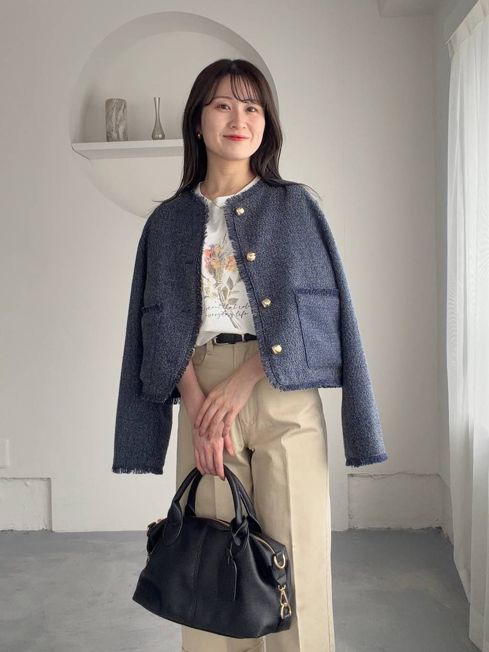 ブラック系のボストンバッグ、ブラック系のサンダル、ホワイト系のTシャツ/カットソーを着用したレディースの春コーディネートの3枚目の写真