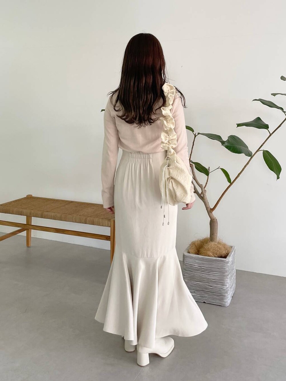 ホワイト系のハンドバッグ、ホワイト系のブーツ、ホワイト系のスカートを着用したレディースの秋コーディネートの6枚目の写真