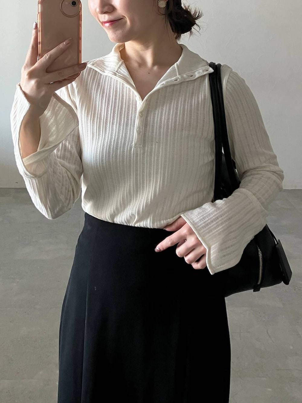 ブラック系のハンドバッグ、ベージュ系のテーラードジャケット、ブラック系のパンプスを着用したレディースの冬コーディネートの5枚目の写真