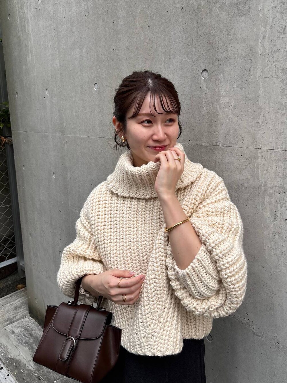 ホワイト系のニット/セーター、グレー系のスカートを着用したレディースの秋コーディネートの3枚目の写真