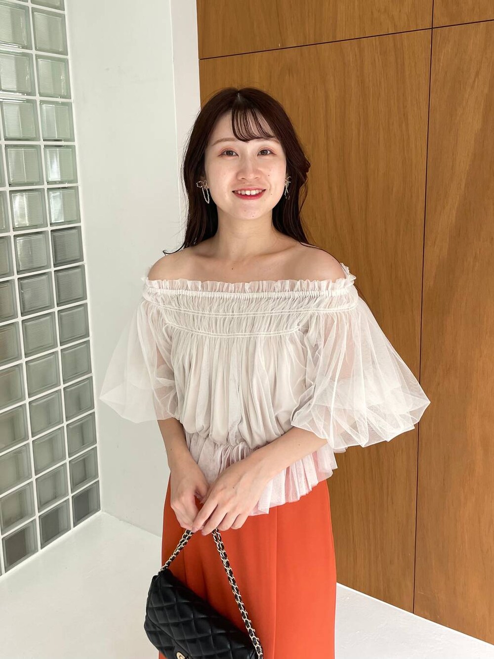 ブラック系のパンプス、ホワイト系のシャツ/ブラウス、ブラック系のショルダーバッグを着用したレディースの夏コーディネートの4枚目の写真