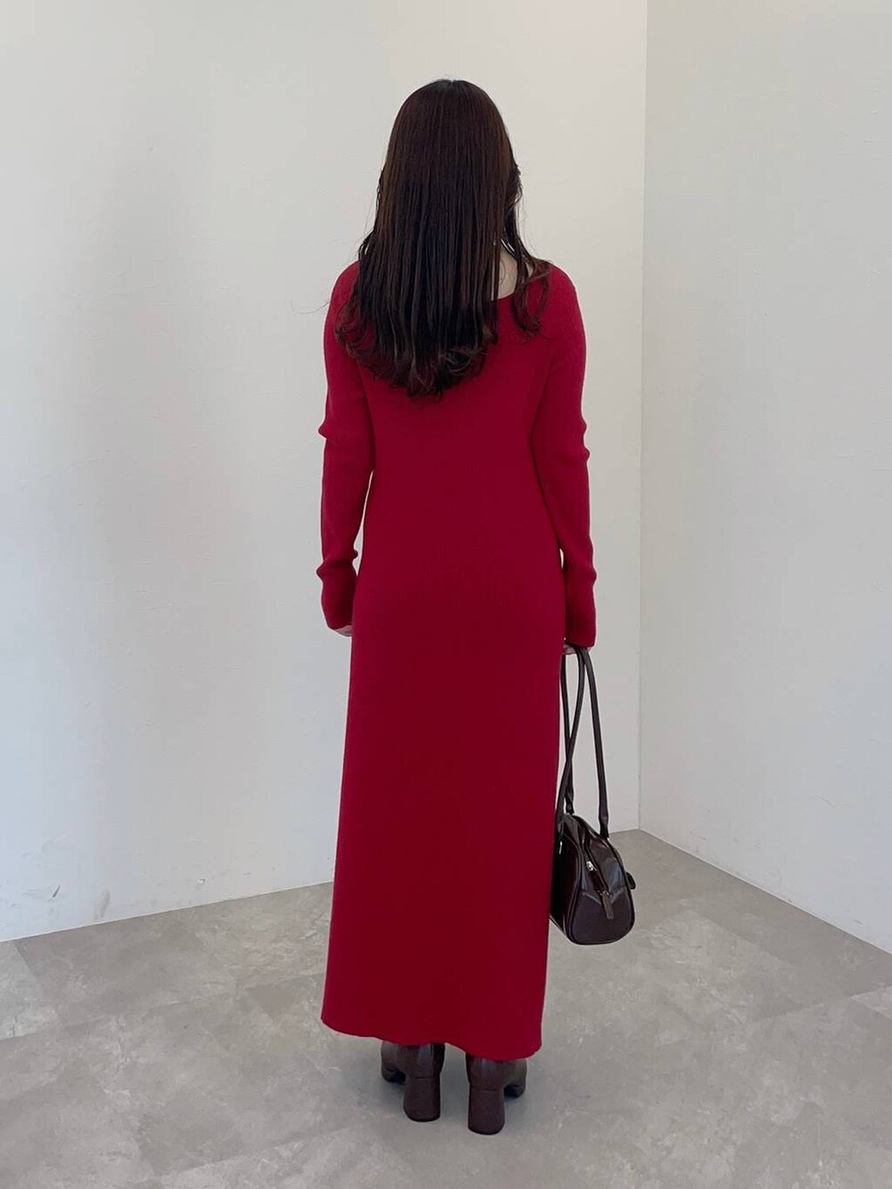 ブラウン系のブーツ、ブラウン系のハンドバッグ、レッド系のワンピースを着用したレディースの冬コーディネートの2枚目の写真