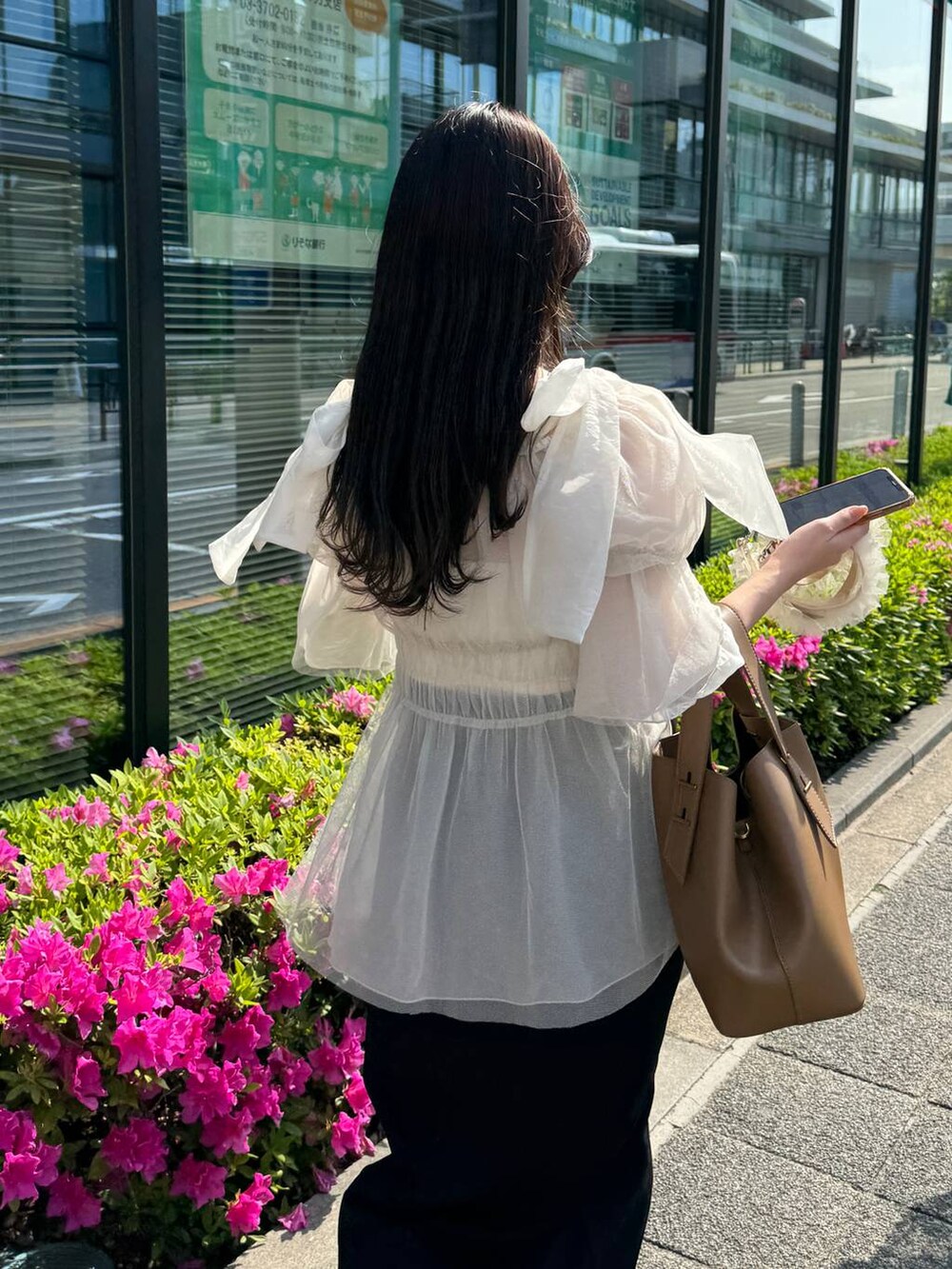 ブラック系のスカート、ホワイト系のシャツ/ブラウスを着用したレディースの春コーディネートの4枚目の写真