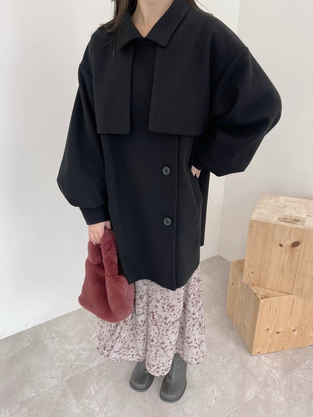 ブラック系のチェスターコート、グレー系のブーツ、ピンク系のハンドバッグを着用したレディースの秋コーディネートの3枚目の写真