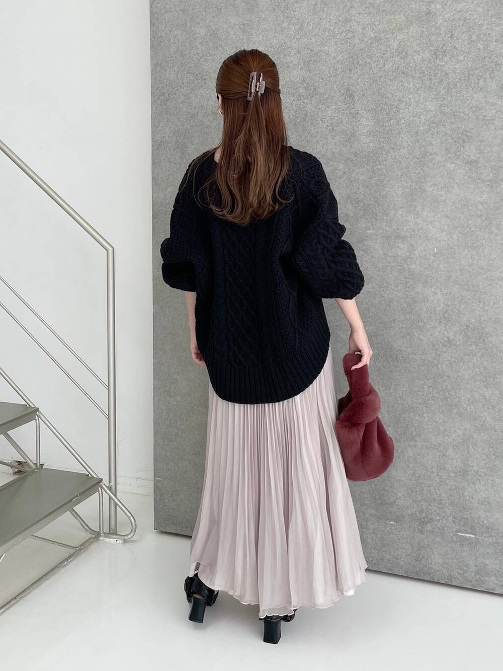 ブラック系のパンプス、ブラック系のカーディガン/ボレロ、ピンク系のハンドバッグを着用したレディースの秋コーディネートの2枚目の写真