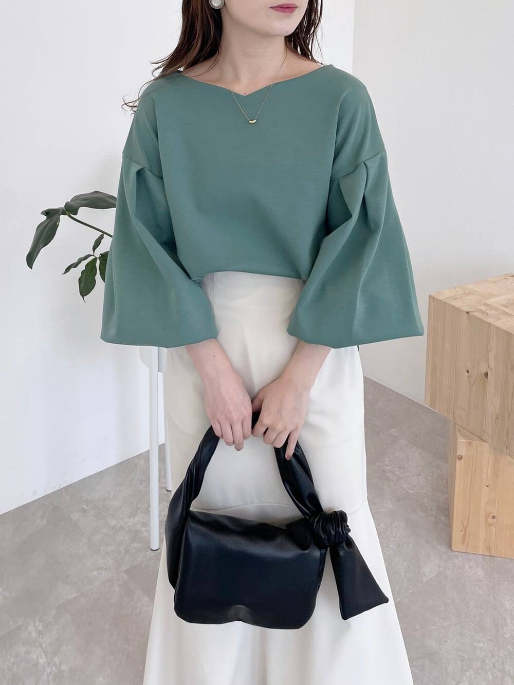 ブラック系のその他シューズ、グリーン系のTシャツ/カットソー、ブラック系のハンドバッグを着用したレディースの夏コーディネートの3枚目の写真