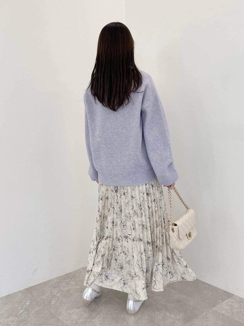 パープル系のニット/セーター、ホワイト系のショルダーバッグ、ホワイト系のノーカラーコートを着用したレディースの冬コーディネートの5枚目の写真