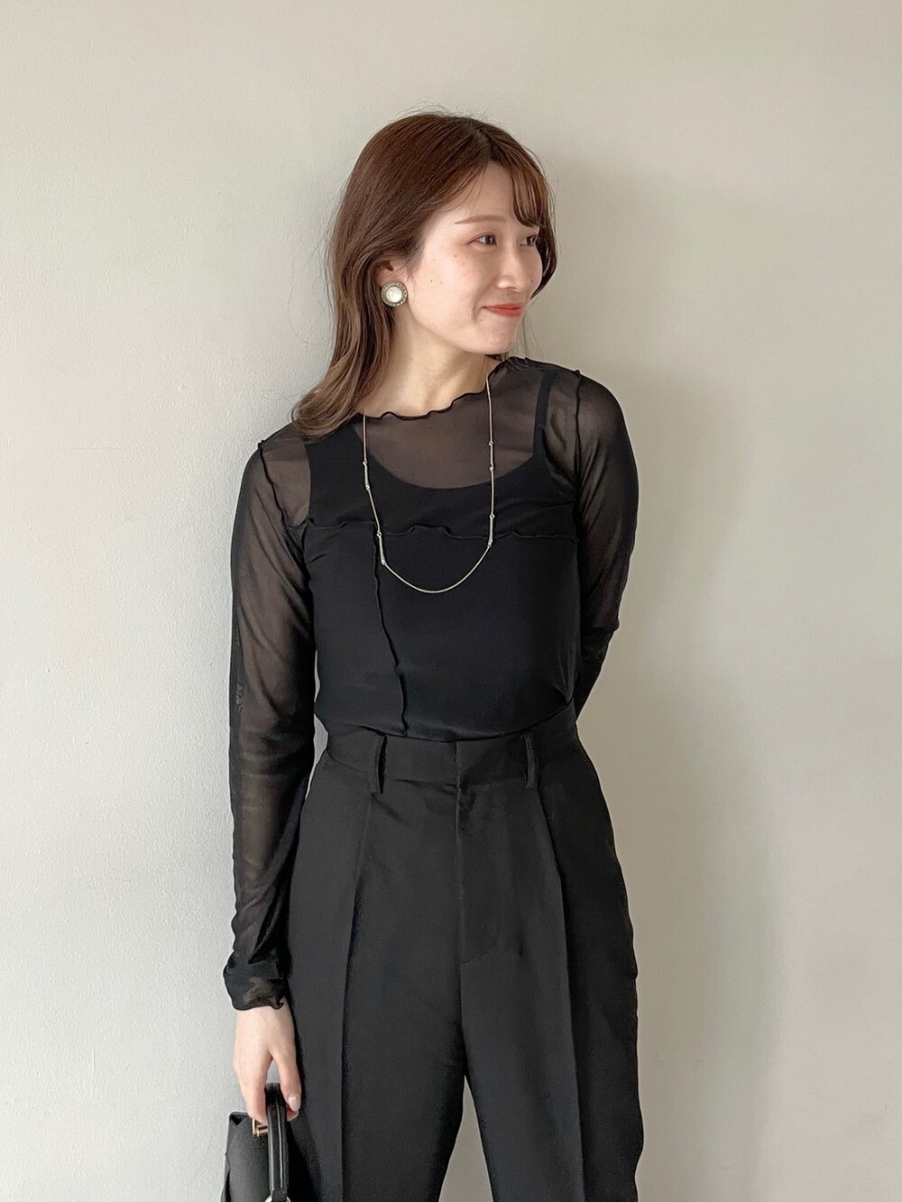 ブラック系のTシャツ/カットソー、ブラック系のその他トップス、ブラック系のスラックスを着用したレディースの春コーディネートの3枚目の写真