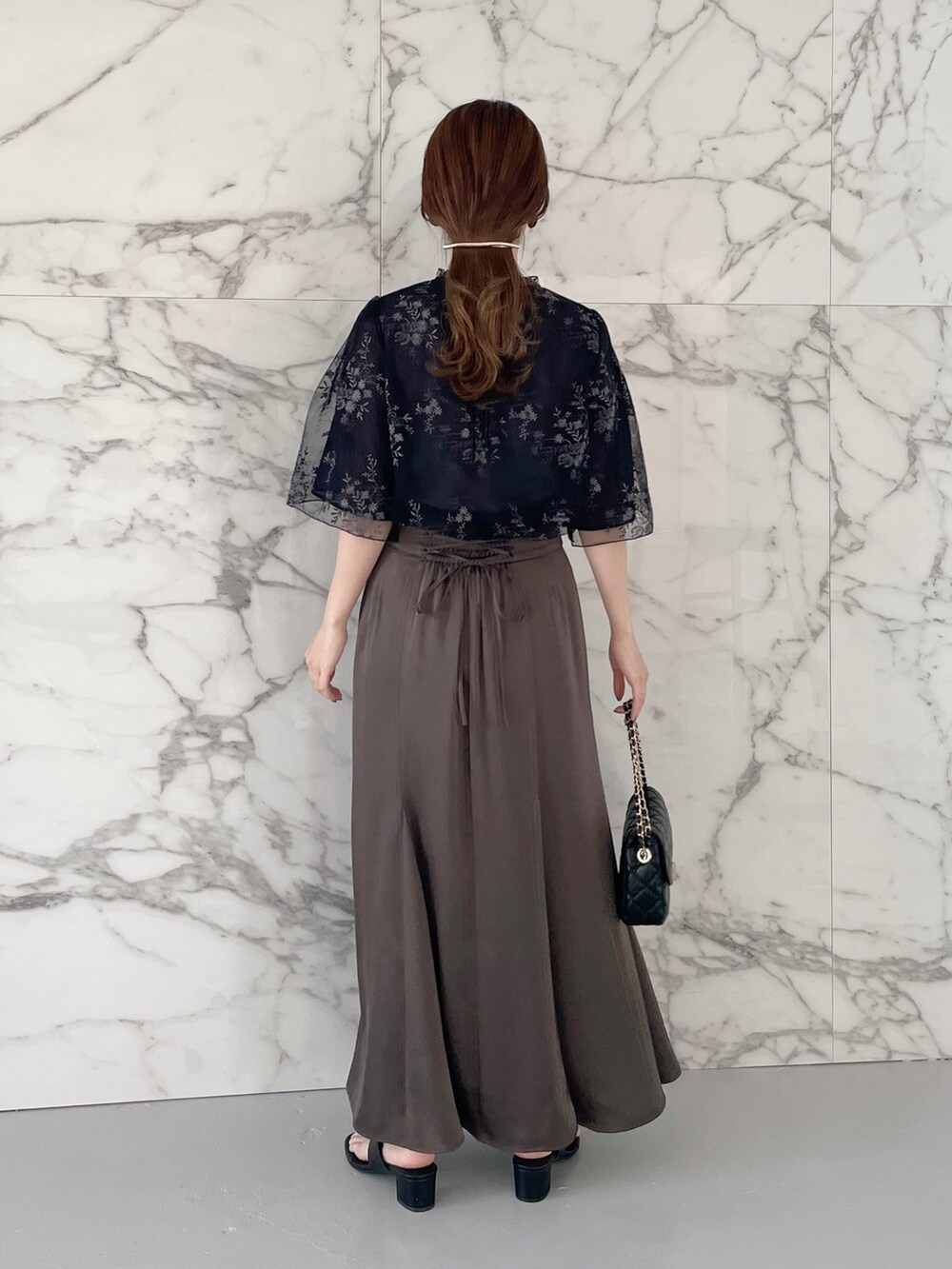 ホワイト系のタンクトップ、ブルー系のシャツ/ブラウス、ブラウン系のスカートを着用したレディースの春コーディネートの2枚目の写真