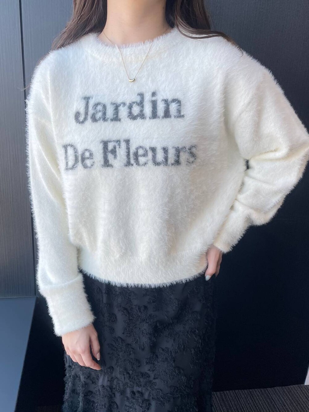 ホワイト系のニット/セーター、グレー系のブーツ、ブラック系のワンピースを着用したレディースの冬コーディネートの3枚目の写真