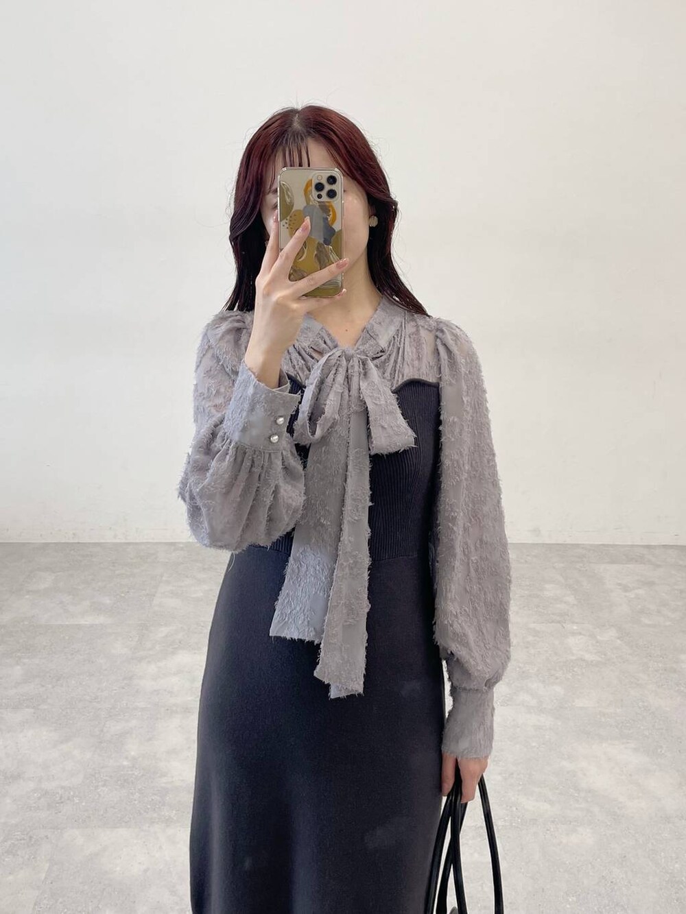 ホワイト系のブルゾン、ブラック系のブーツ、グレー系のワンピースを着用したレディースの秋コーディネートの8枚目の写真