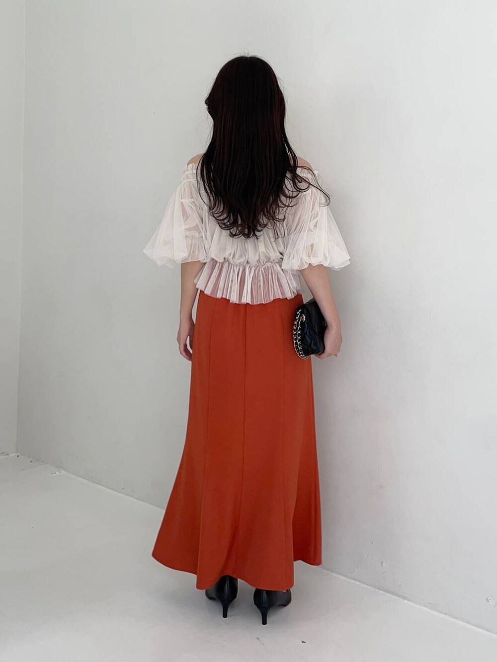 ブラック系のパンプス、ホワイト系のシャツ/ブラウス、ブラック系のショルダーバッグを着用したレディースの夏コーディネートの2枚目の写真