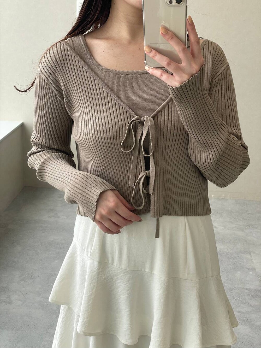 ホワイト系のスカート、ベージュ系のショルダーバッグ、ブラウン系のパンプスを着用したレディースの冬コーディネートの3枚目の写真