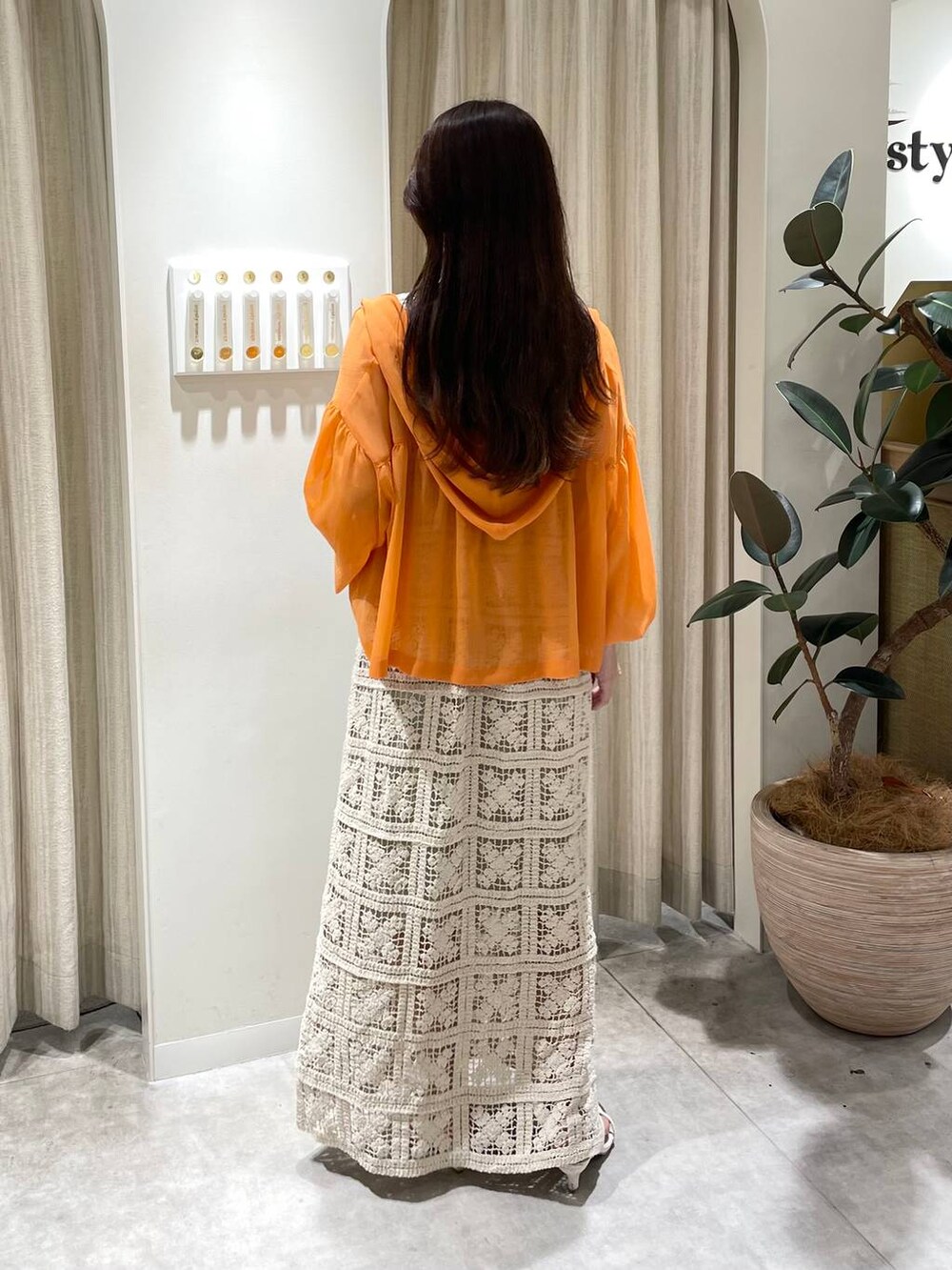 ホワイト系のワンピース、オレンジ系のパーカー、ホワイト系のサンダルを着用したレディースの夏コーディネートの3枚目の写真