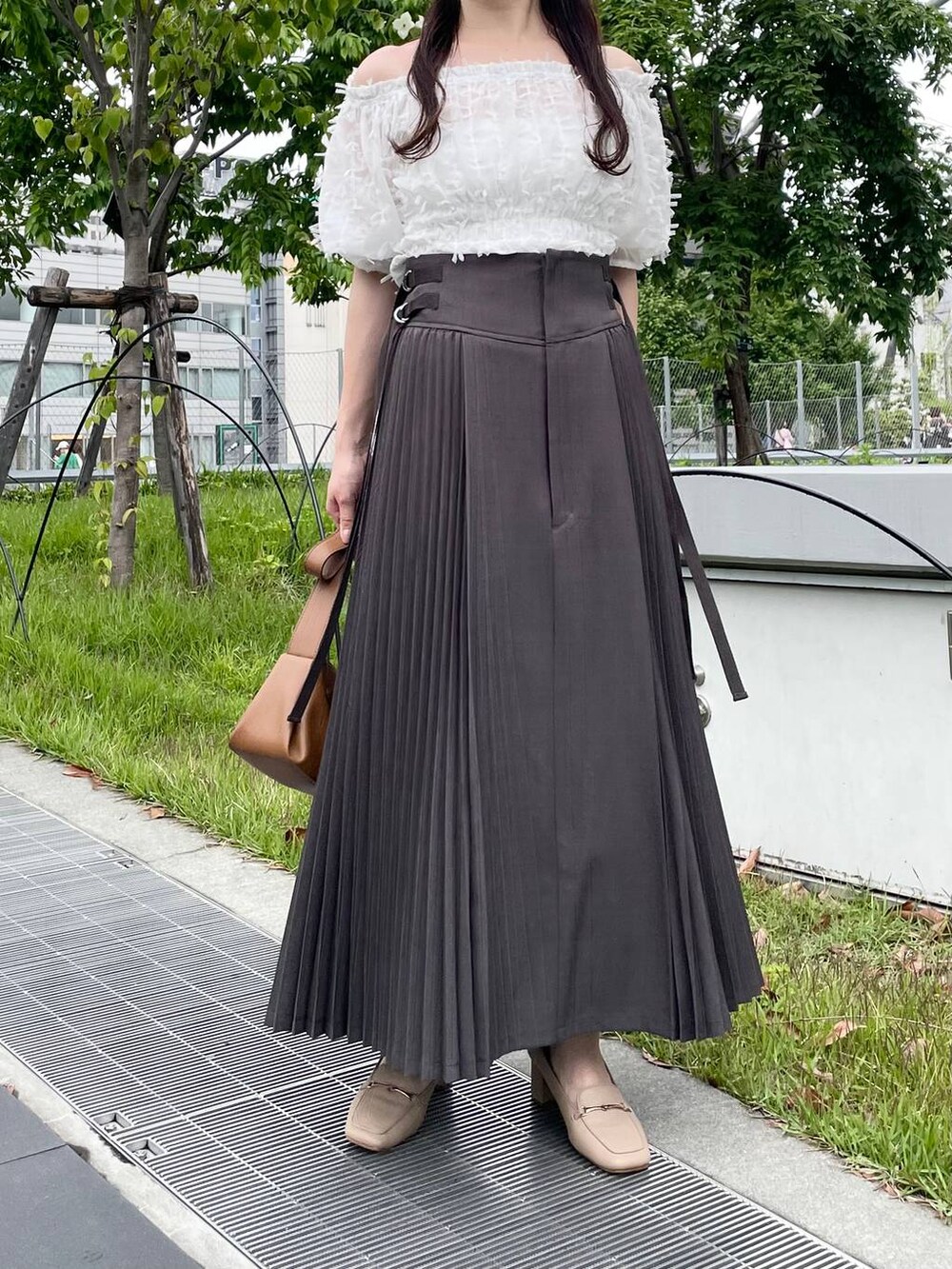 ブラウン系のショルダーバッグ、グレー系のスカート、ホワイト系のシャツ/ブラウスを着用したレディースの夏コーディネートの4枚目の写真