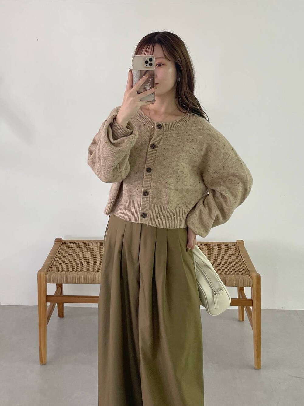 ホワイト系のボストンバッグ、ホワイト系のブーツ、ベージュ系のカーディガン/ボレロを着用したレディースの秋コーディネートの5枚目の写真