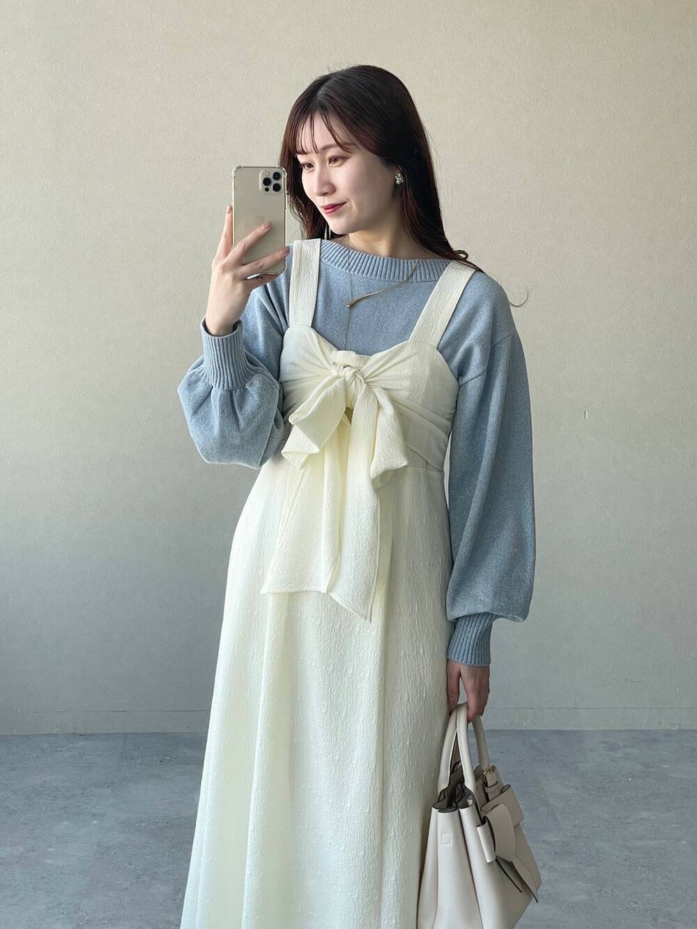 ブルー系のニット/セーター、ホワイト系のショルダーバッグ、シルバー系のバレエシューズを着用したレディースの春コーディネートの3枚目の写真