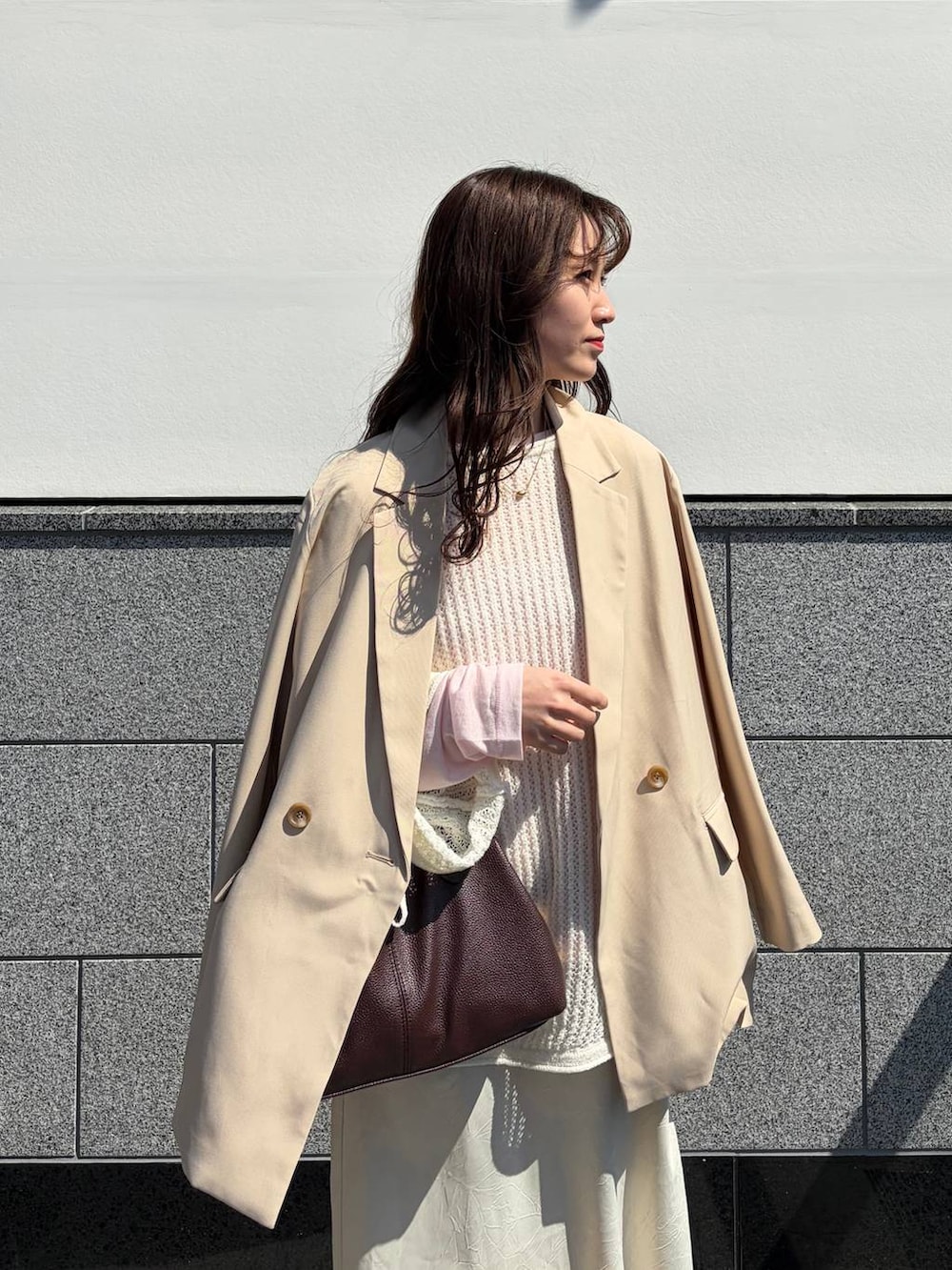 ホワイト系のスカート、ピンク系のTシャツ/カットソー、ブラウン系のボストンバッグを着用したレディースの春コーディネートの4枚目の写真