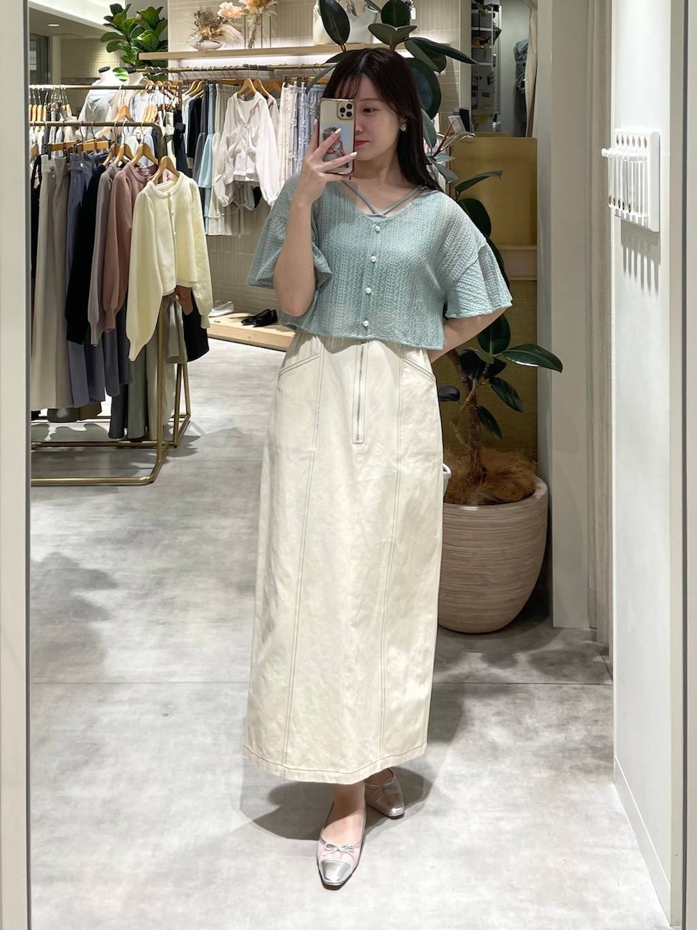 シルバー系のバレエシューズ、グリーン系のカーディガン/ボレロ、ホワイト系のスカートを着用したレディースの春コーディネートの3枚目の写真