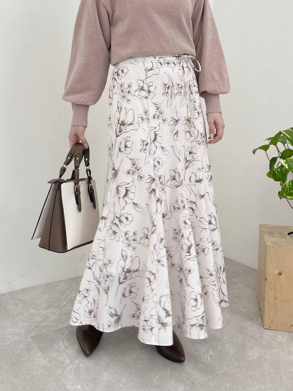 ピンク系のニット/セーター、ブラウン系のブーツ、ホワイト系のトートバッグを着用したレディースの冬コーディネートの4枚目の写真