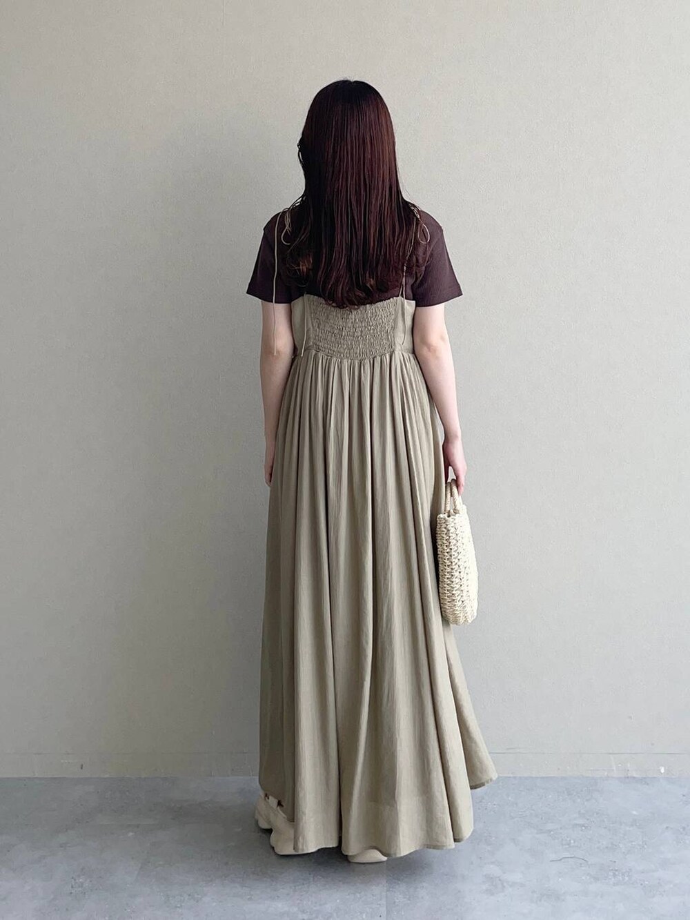 ホワイト系のサンダル、ベージュ系のワンピース、ベージュ系のかごバッグを着用したレディースの春コーディネートの2枚目の写真