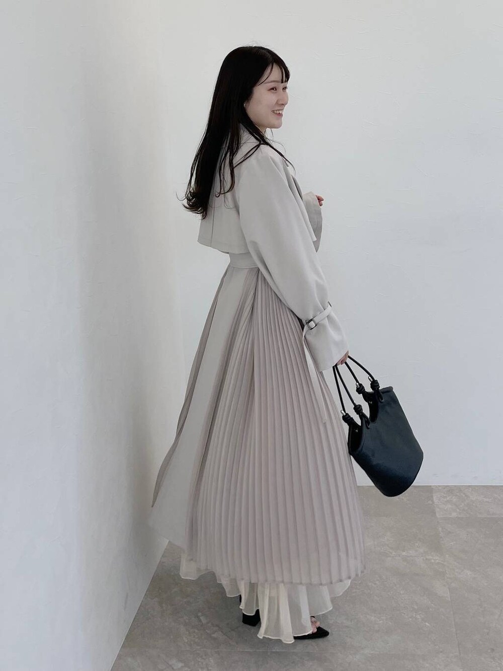 ベージュ系のワンピース、ブラック系のハンドバッグ、ブラック系のブーツを着用したレディースの冬コーディネートの3枚目の写真