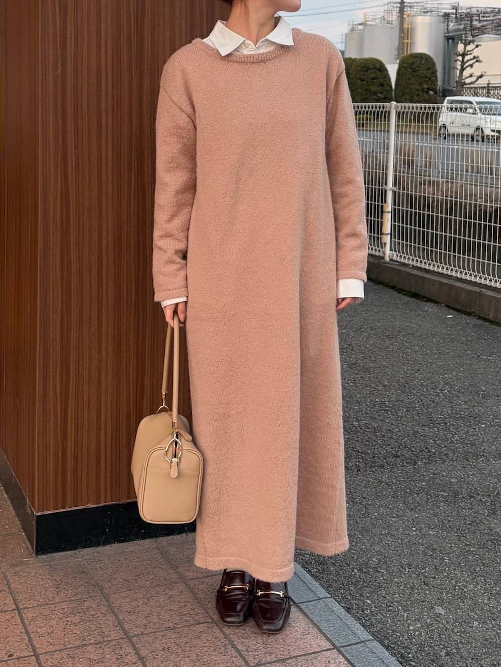 ゴールド系のボストンバッグ、ピンク系のワンピースを着用したレディースの冬コーディネートの2枚目の写真