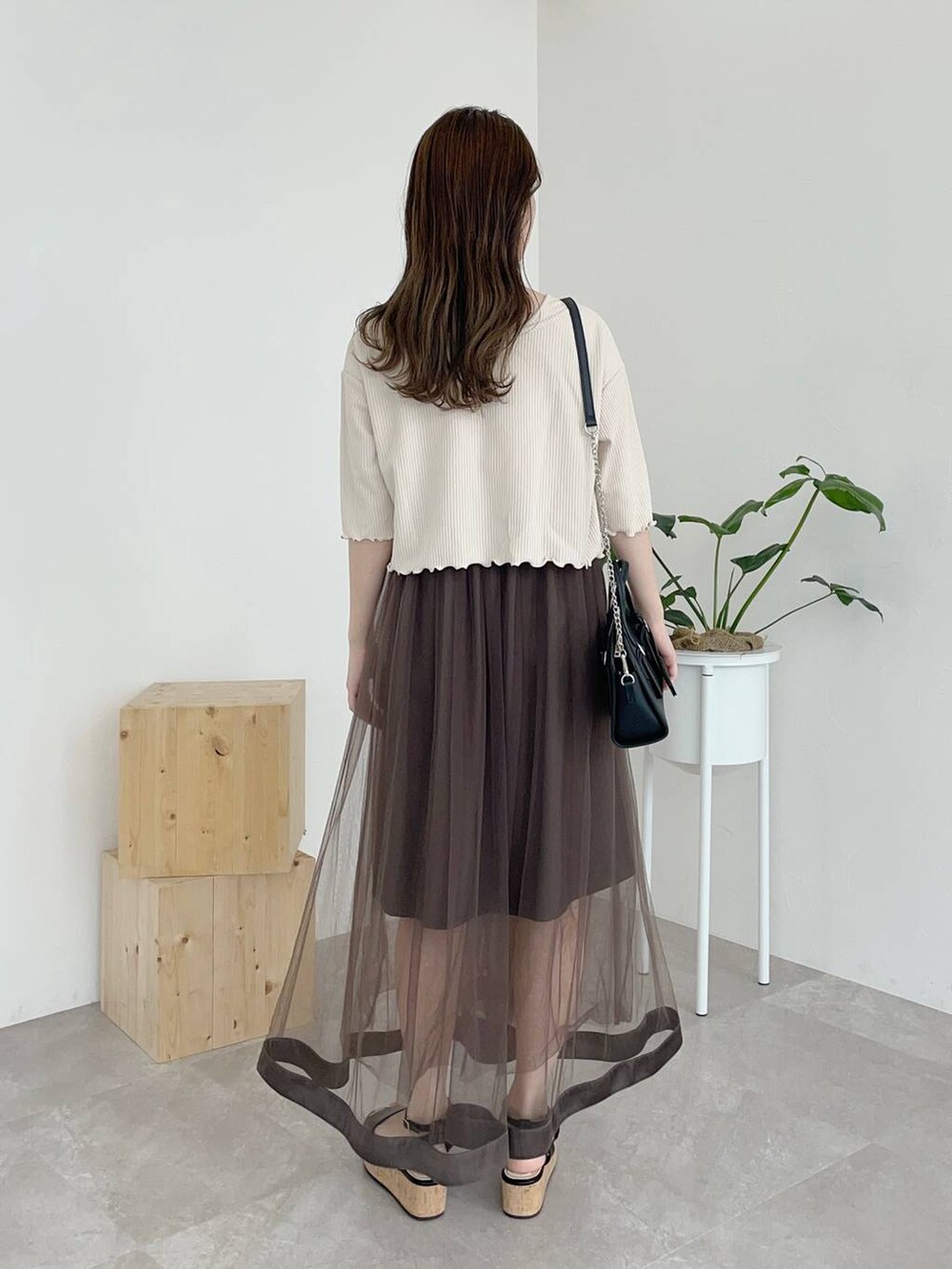 ホワイト系のカーディガン/ボレロ、ブラック系のサンダル、ブラック系のボストンバッグを着用したレディースの夏コーディネートの2枚目の写真