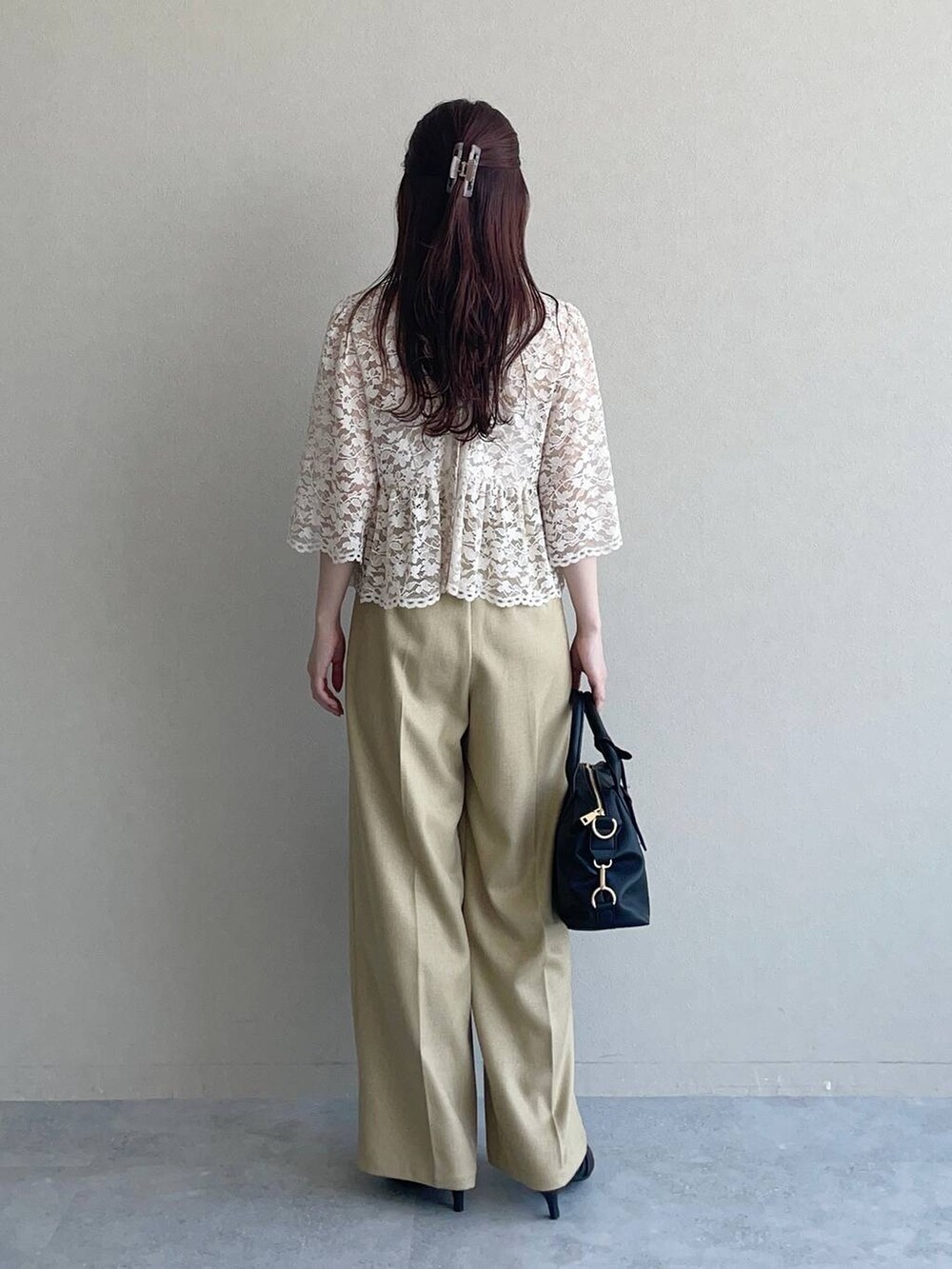 ブラック系のパンプス、ブラック系のボストンバッグ、ベージュ系のシャツ/ブラウスを着用したレディースの夏コーディネートの2枚目の写真