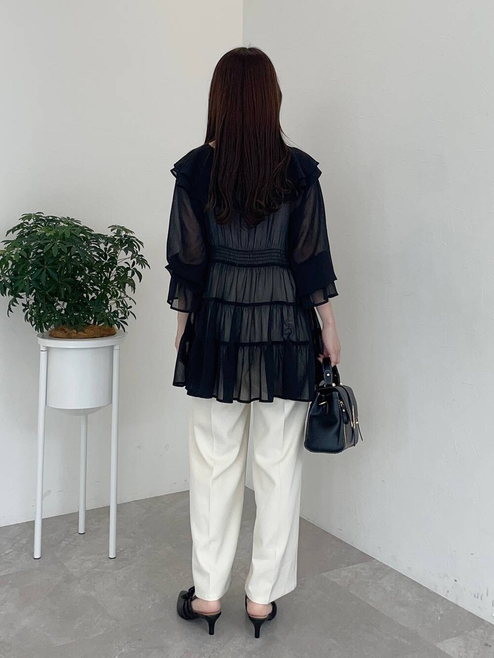 ブラック系のパンプス、ブラック系のショルダーバッグ、ブラック系のシャツ/ブラウスを着用したレディースの夏コーディネートの2枚目の写真