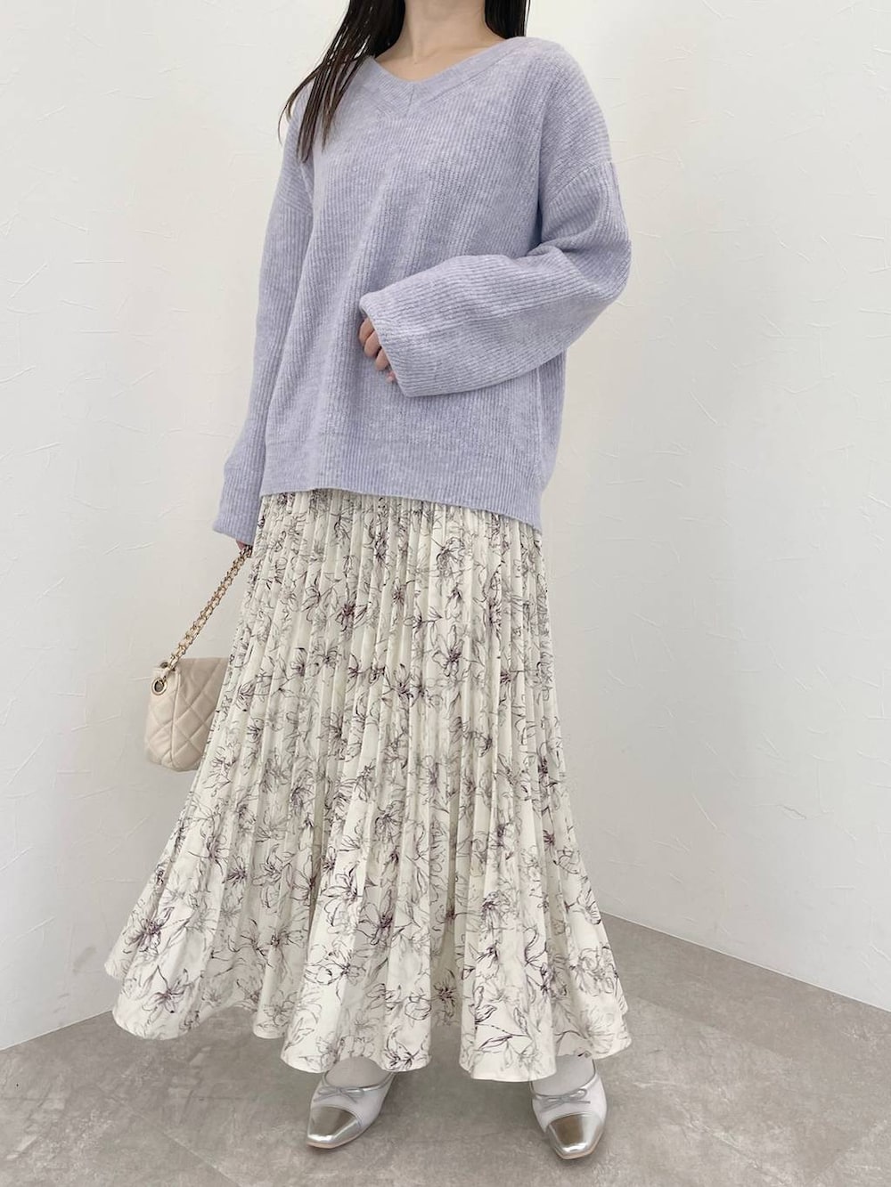 パープル系のニット/セーター、ホワイト系のショルダーバッグ、ホワイト系のスカートを着用したレディースの冬コーディネートの4枚目の写真