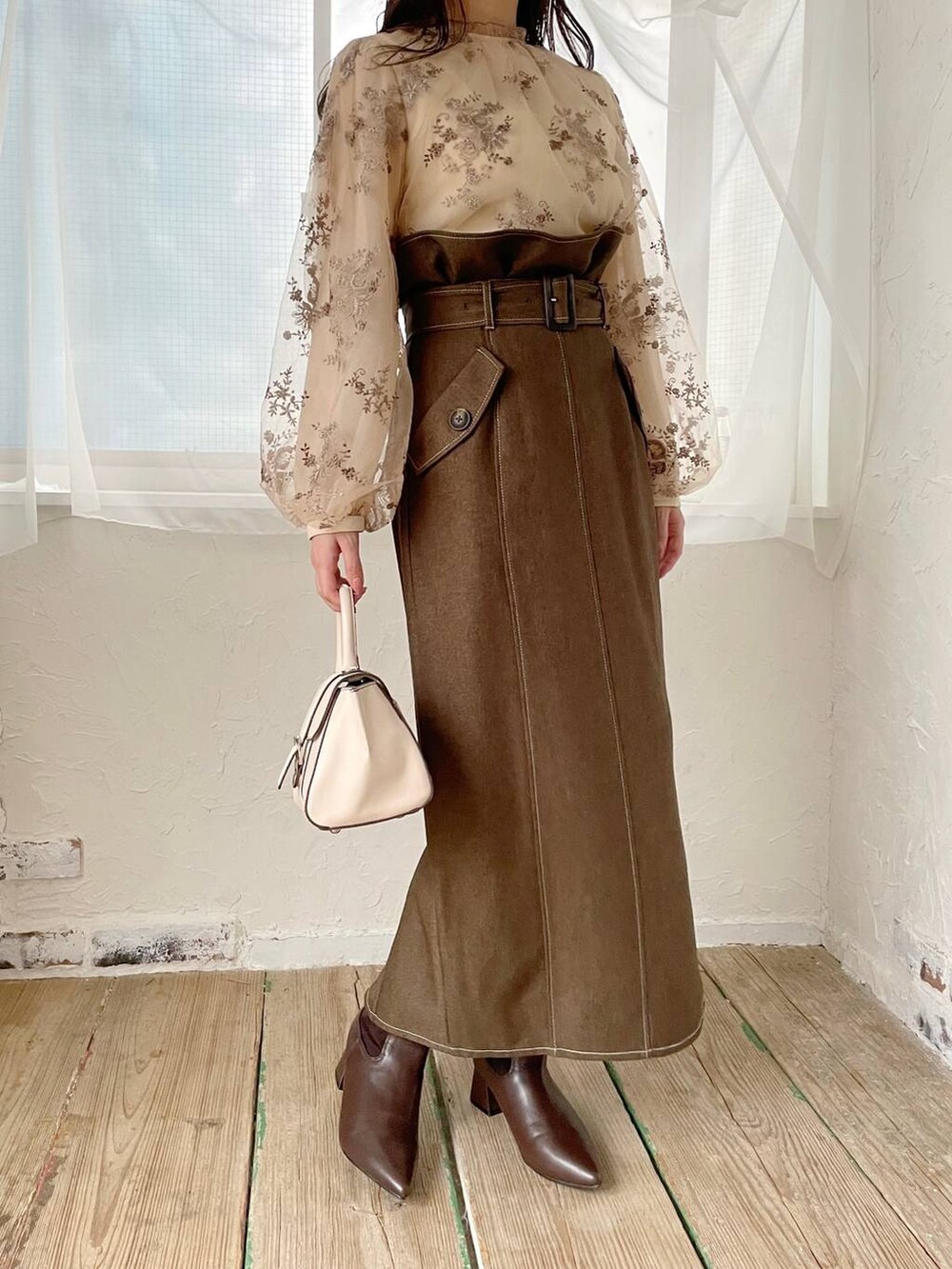 ホワイト系のハンドバッグ、ホワイト系のシャツ/ブラウス、ブラウン系のブーツを着用したレディースの秋コーディネートの7枚目の写真