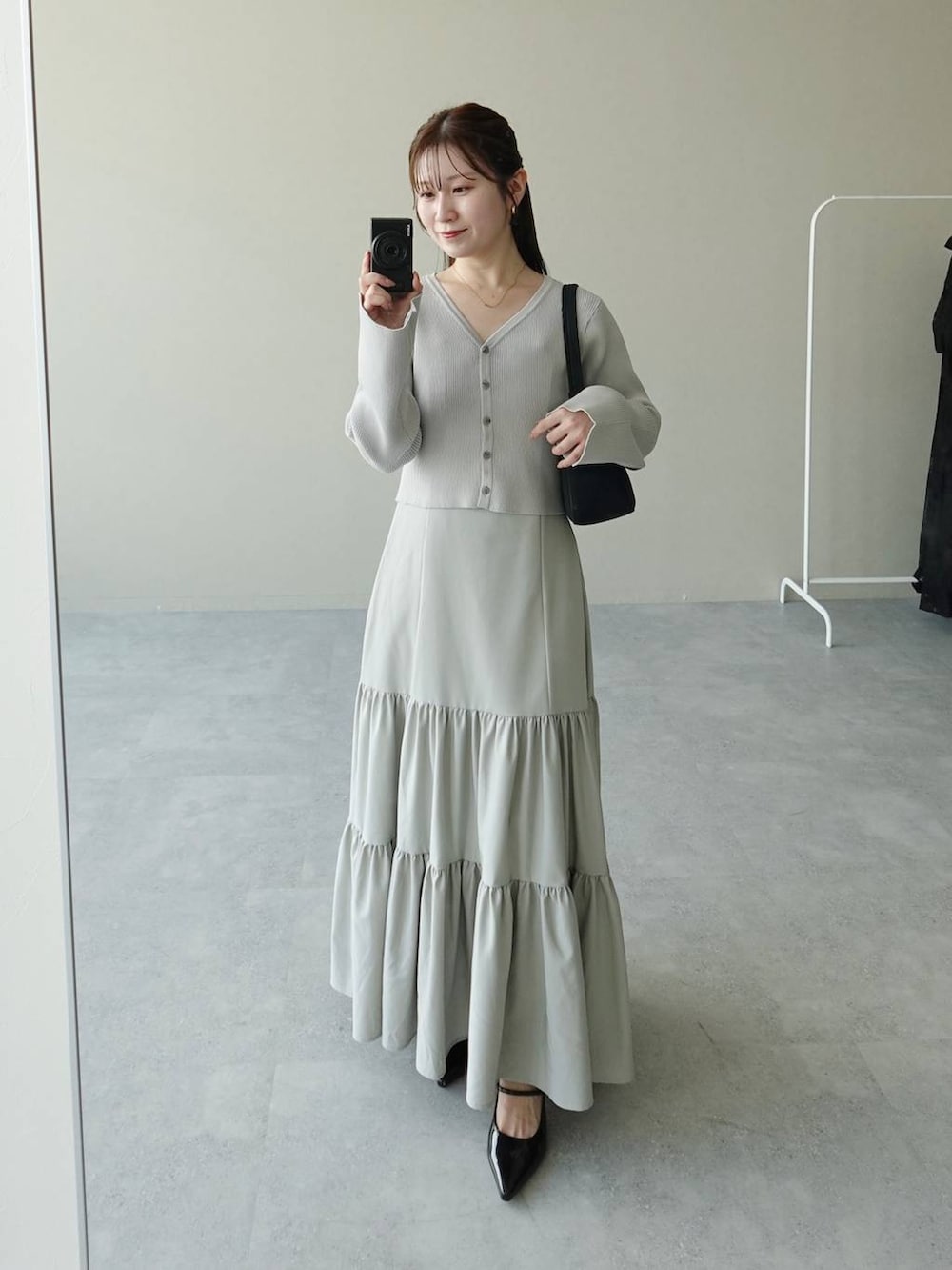 グレー系のワンピース、ブラック系のサンダル、ブラック系のショルダーバッグを着用したレディースの夏コーディネートの3枚目の写真
