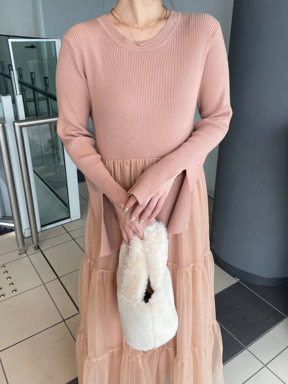 グレー系のブーツ、ホワイト系のハンドバッグ、オレンジ系のワンピースを着用したレディースの秋コーディネートの3枚目の写真