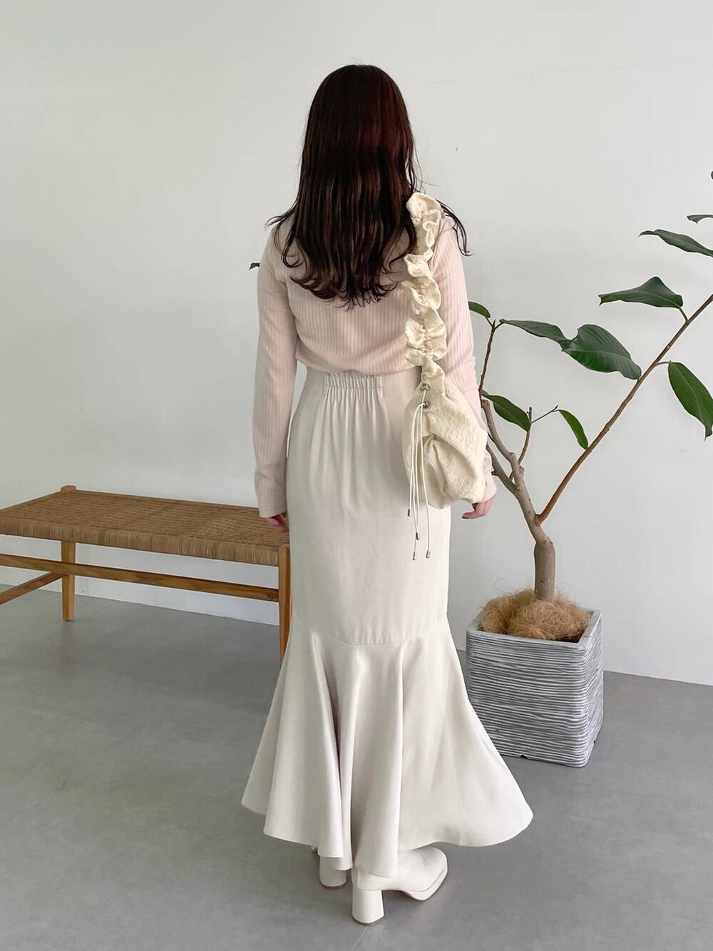 ホワイト系のハンドバッグ、ホワイト系のブーツ、ホワイト系のスカートを着用したレディースの秋コーディネートの2枚目の写真