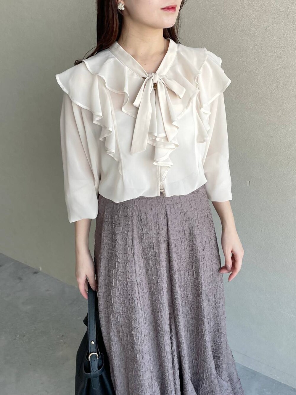 ブラック系のショルダーバッグ、ブラウン系のスカート、ホワイト系のシャツ/ブラウスを着用したレディースの冬コーディネートの3枚目の写真