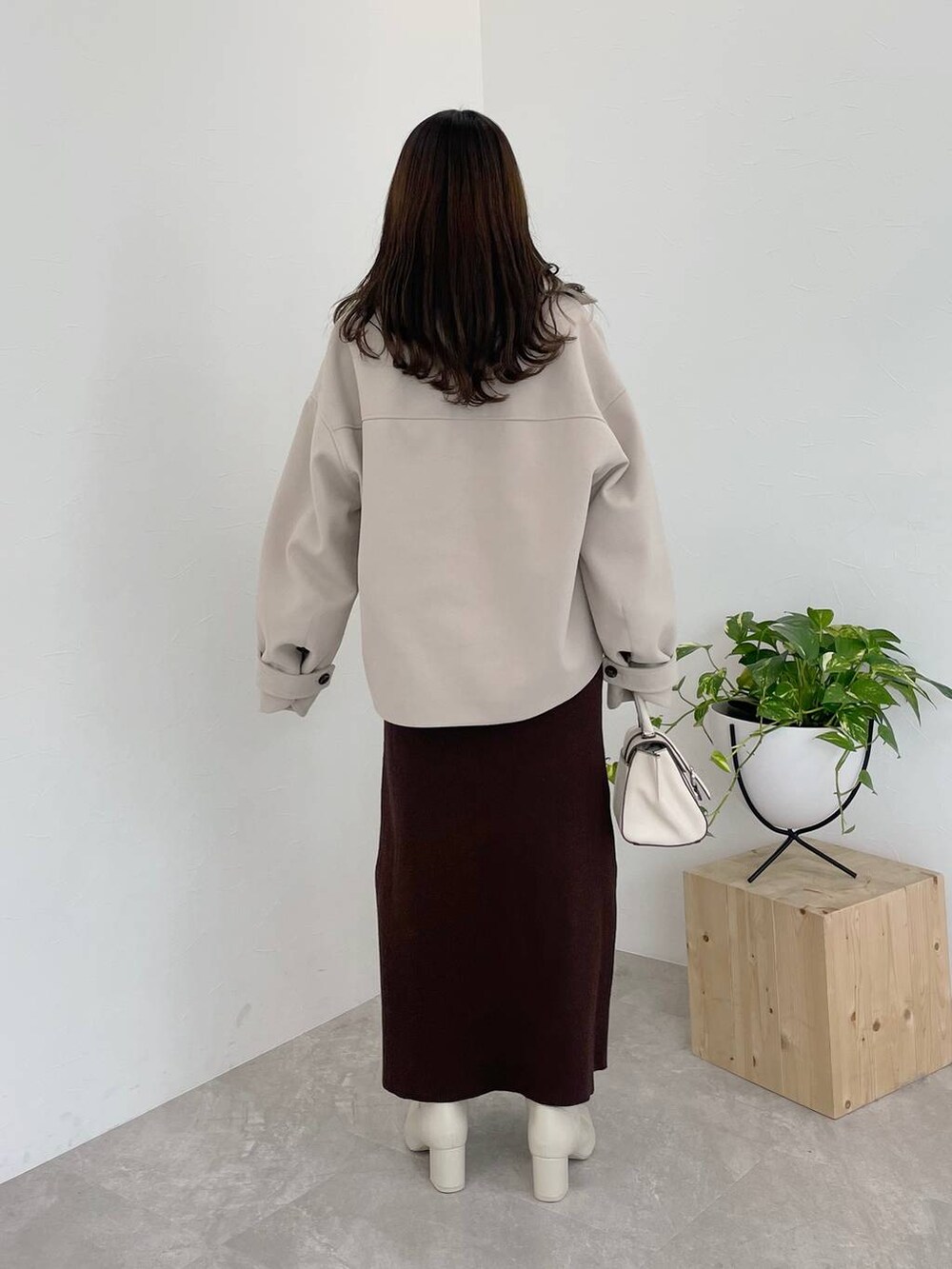 ホワイト系のその他アウター、ホワイト系のハンドバッグ、ホワイト系のブーツを着用したレディースの冬コーディネートの3枚目の写真