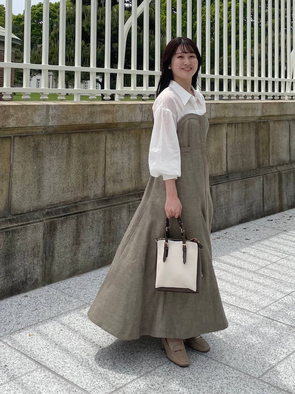 ベージュ系のワンピース、ホワイト系のトートバッグを着用したレディースの春コーディネートの2枚目の写真