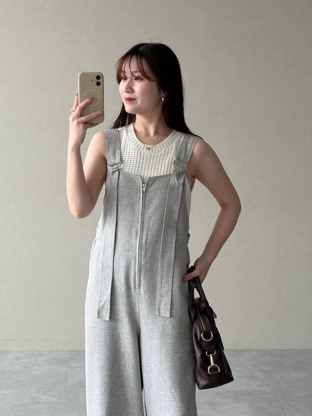 グリーン系のパーカー、ブラウン系のボストンバッグ、ブラウン系のサンダルを着用したレディースの春コーディネートの6枚目の写真