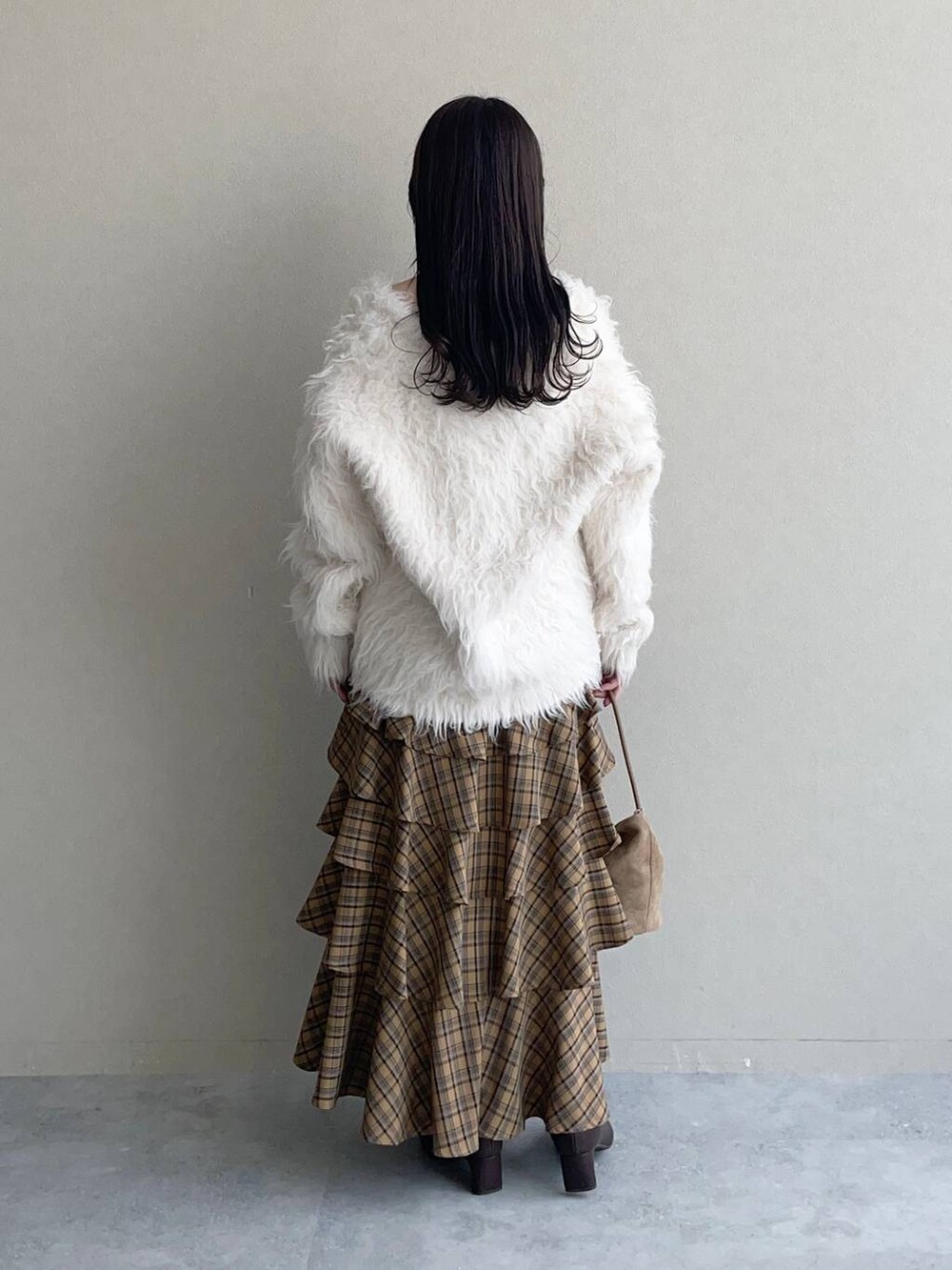 ホワイト系のカーディガン/ボレロ、ベージュ系のスカート、ブラウン系のタンクトップを着用したレディースの秋コーディネートの2枚目の写真