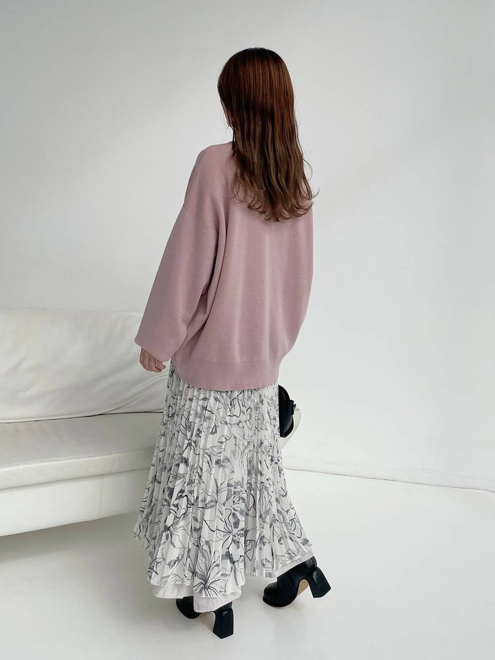 ブラック系のボストンバッグ、ブラック系のブーツ、ピンク系のニット/セーターを着用したレディースの秋コーディネートの2枚目の写真