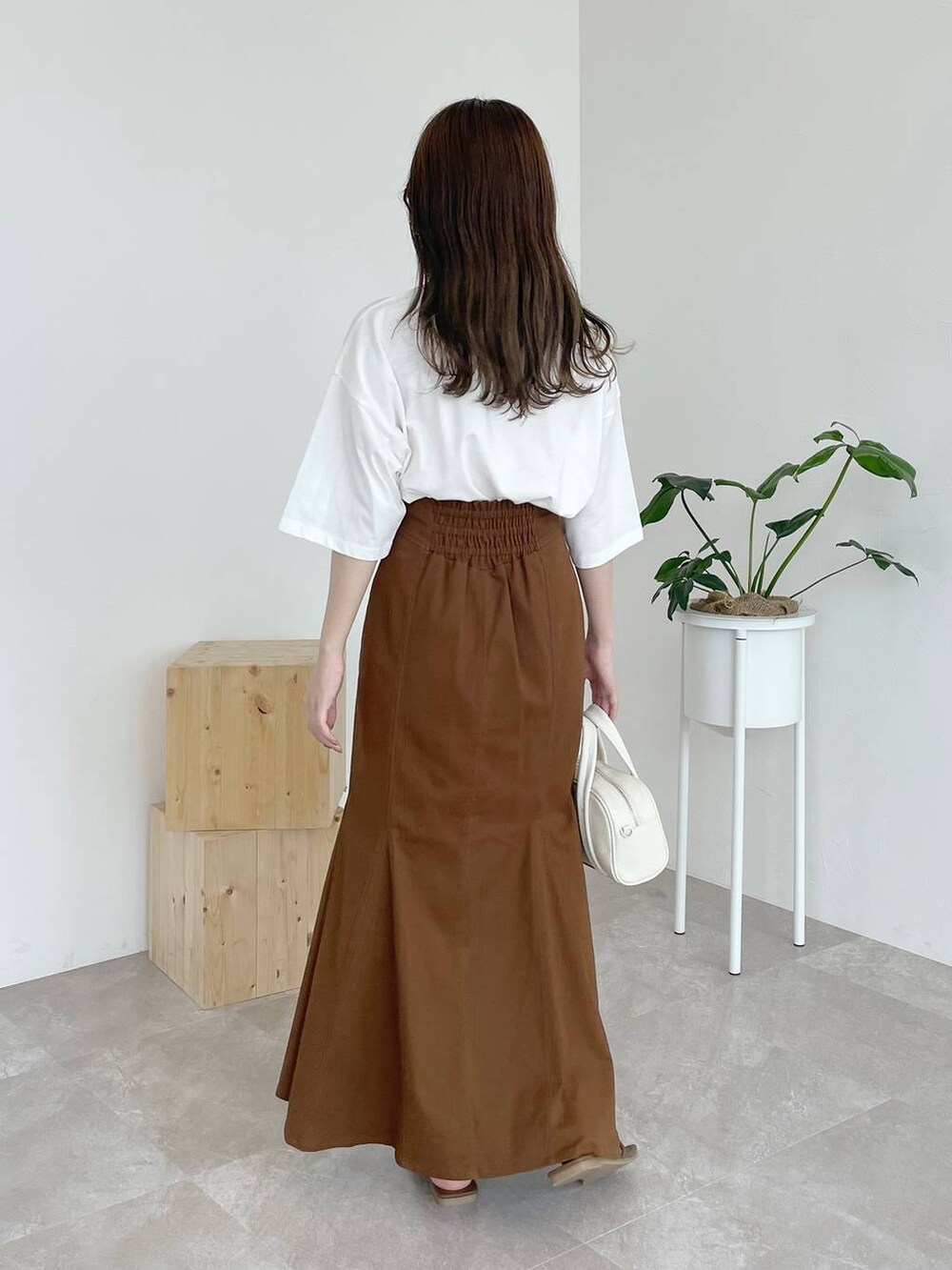 ブラウン系のサンダル、ホワイト系のTシャツ/カットソー、ホワイト系のボストンバッグを着用したレディースの夏コーディネートの3枚目の写真