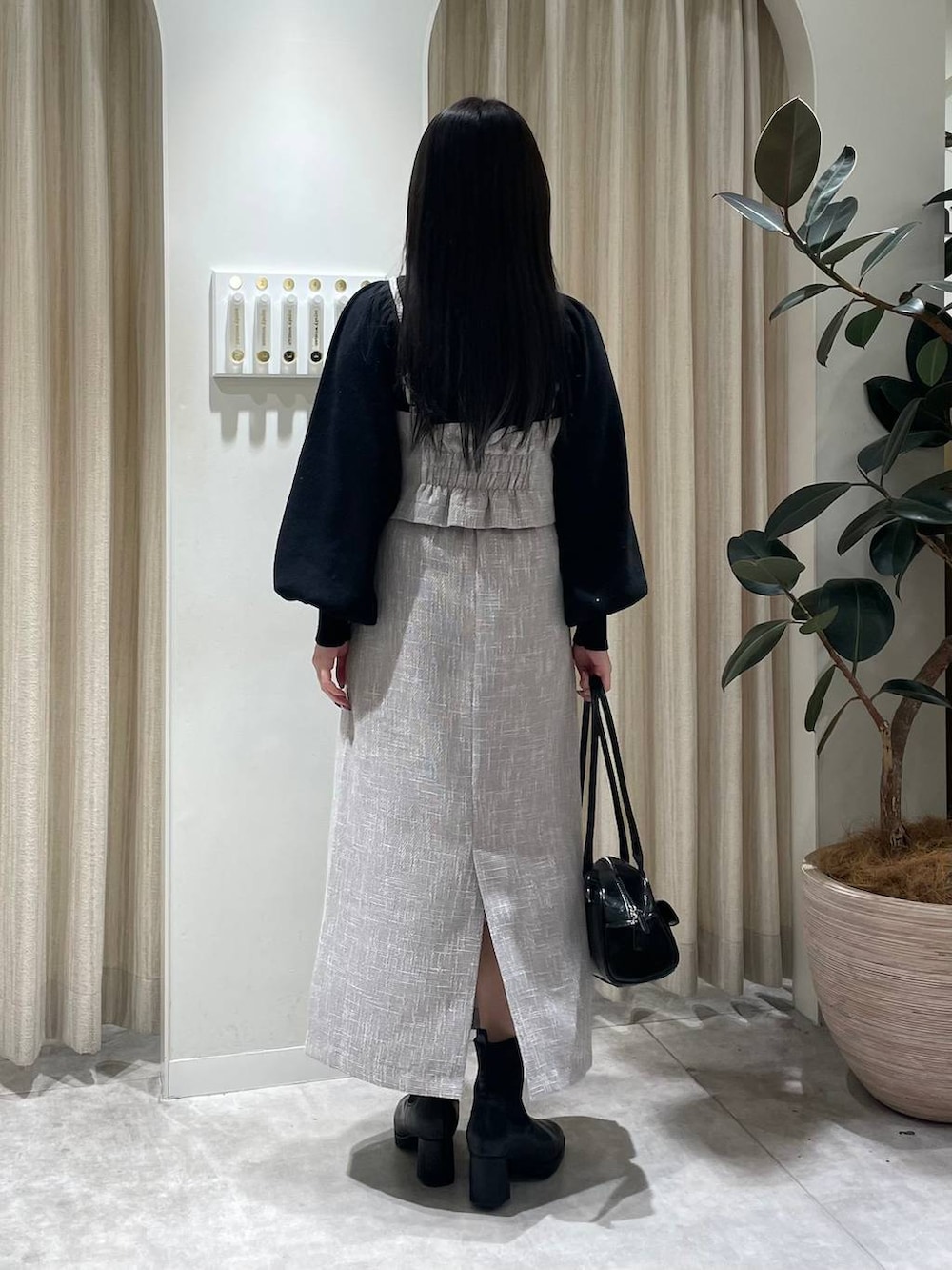 ブラック系のブーツ、ブラック系のハンドバッグ、ブラック系のニット/セーターを着用したレディースの冬コーディネートの2枚目の写真